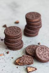 Chocolate sandwich cookies with cocoa cream filing on grey concrete background. Copy space.