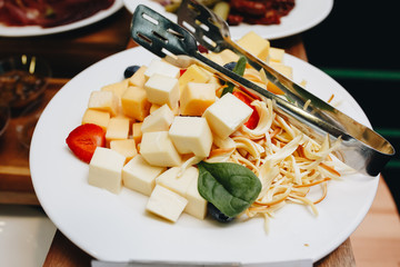 Cheese platter with different varieties on white plate.
