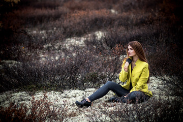 Woman sitting in the dry black bushes