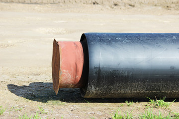 A modern large-diameter water pipe with insulation to save heat, manufactured using new technologies, lies on the ground at the site of the elimination of a water supply accident