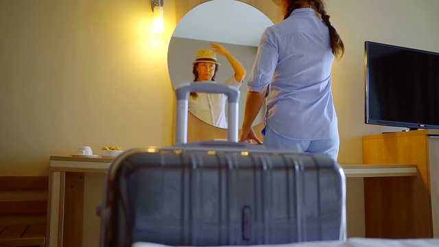middle-aged woman is evicted from the hotel room looks in the mirror and goes out taking a suitcase with things