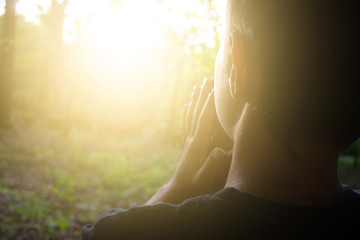 boy worship God with hands up in forest. Nature background