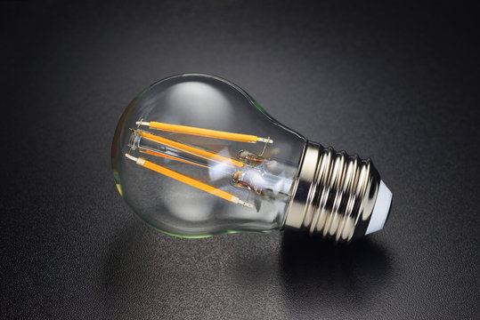 LED filament bulb on black