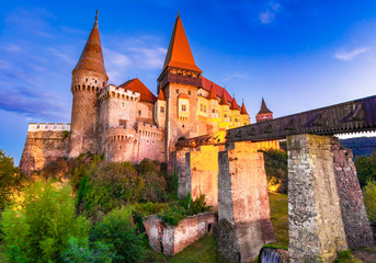 Fototapeta premium Corvin Castle or Hunyad, Hunedoara, Romania: Night view of the Corvin's Castle in the sunset lights, Hunedoara, Transylvania, Romania, Europe