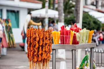 Bocadillos tropicales típicos en México. Brochetas de camarón con limón y chile. Vasos de fruta, mango, sandía y pepino. - obrazy, fototapety, plakaty