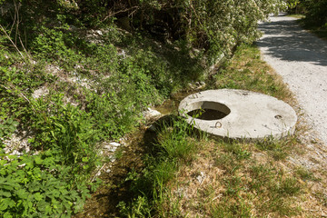 Contaminated water, sewage waste is drained through pipe into sea on an unequipped beach. Pollution...