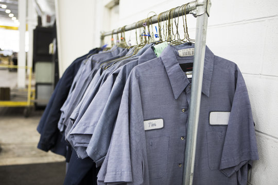 Uniforms hanging on coat hangers in factory