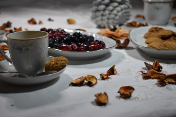 Fototapeta na wymiar Mesa con tazas de cafe, plato con galletas, plato con frutos secos otoñal