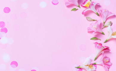 beautiful frame made from pink flowers and pink confetti on pink background.