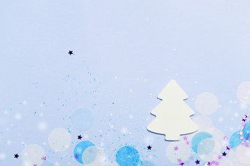 Fototapeta na wymiar Christmas festive banner background: white christmas tree and confetti with sparkling glitter and stars.