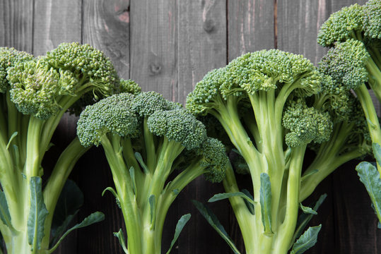 Three broccoli on wooden background