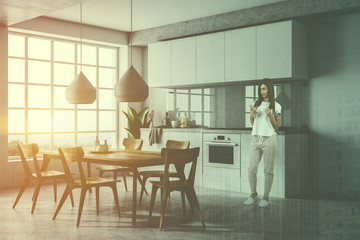 Woman in gray kitchen with table