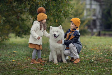 brother and sister hugging dog