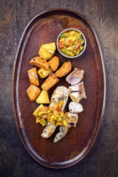 Modern Barbecue Crocodile Tail Eye Fillet With Roasted Sweet Potatoes Pineapples And Mango Chili Chutney As Top View On A Plate