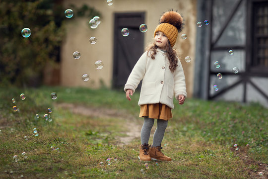 girl playing with soap bubbles outdoors
