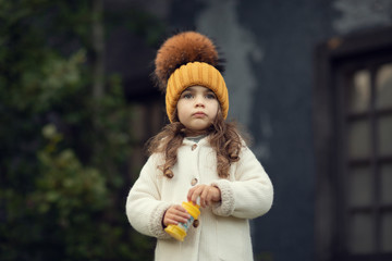 girl holding soap bubbles bottle