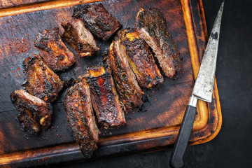 Modern barbecue dry aged wagyu flank steak sliced with green asparagus and fresh berries as top view plate