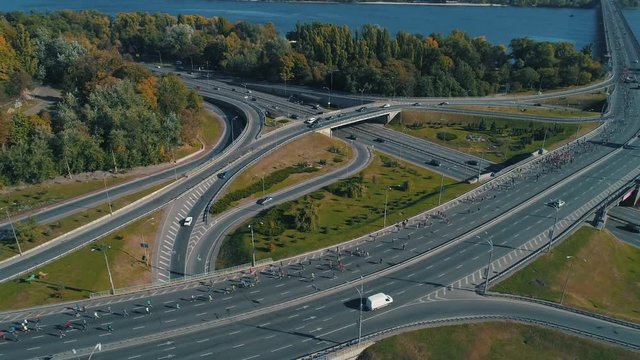 Aerial drone footage. Fly around marathon running on the road junction, wide shot