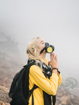 Woman posing in dangerous vapors of volcano