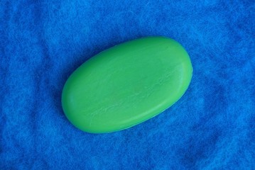 a big piece of green soap on a blue wool background