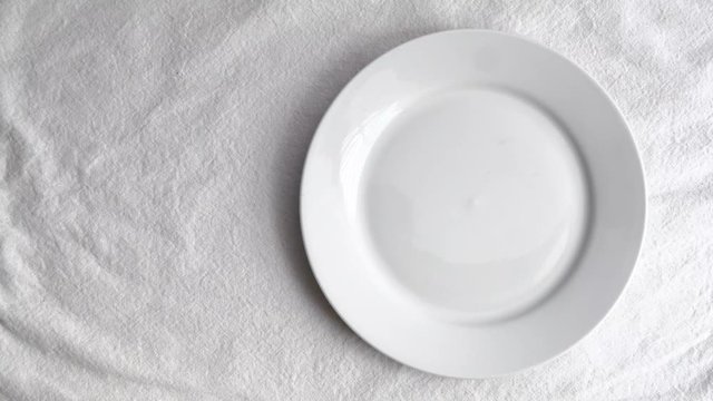 Garlic on white ceramic plate on white table mat