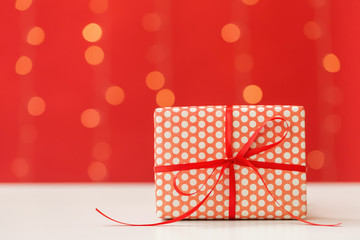 Christmas gift box on a shiny light red background