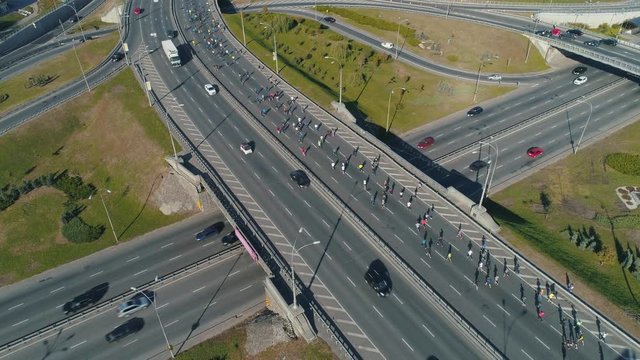 Aerial drone footage. Marathon running group on the road junction, close up static shot
