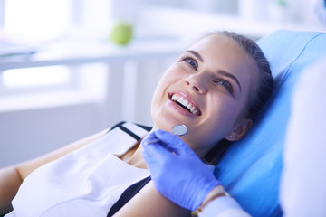 Jonge vrouwelijke patiënt met mooie glimlach die tandheelkundige inspectie onderzoekt op het kantoor van de tandarts.