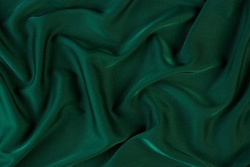 Green silk fabric background, view from above. Smooth elegant green silk or satin luxury cloth...