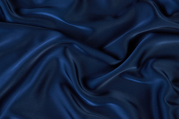 Dark blue silk fabric background, view from above. Smooth elegant blue silk or satin luxury cloth...