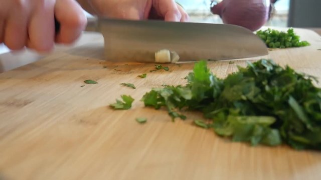 Chopping garlic on cutting board, close up