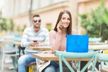 Young beautiful woman in a cafe talking on a smart phone