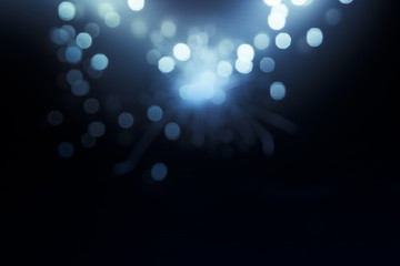 holiday abstract glitter background with blinking stars and falling snowflakes. Blurred bokeh of Christmas lights.