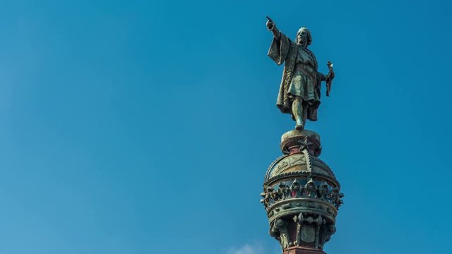 he Columbus Monument in Barcelona. Bronze statue represents Christopher Columbus pointing towards the New World with his right hand. Clouds move fast across the sky.