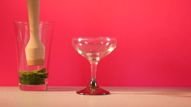 Person uses muddler to prepare drink, close up