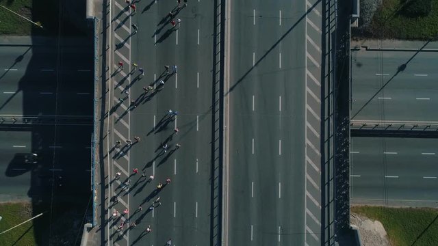 Aerial drone footage. Top view marathon running on the road junction, close up shot