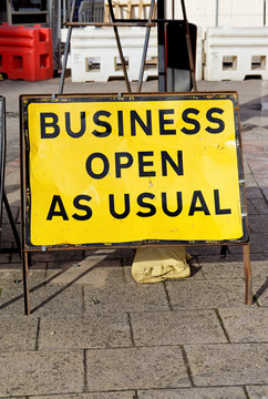 Business open as usual sign on UK street showing concept of economic recovery