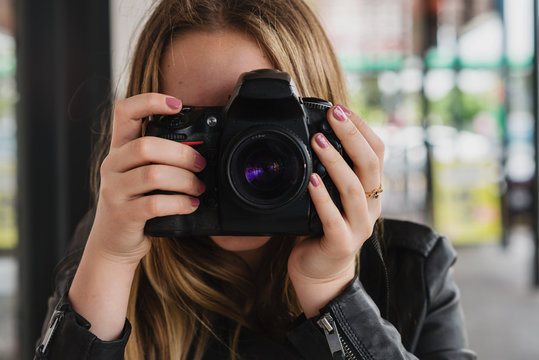 young woman holding large camera