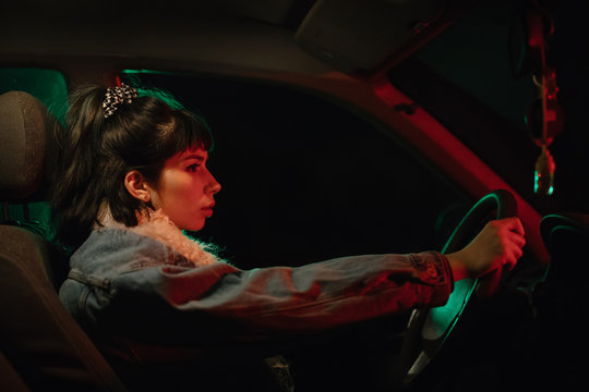 Woman inside of dark cark driving