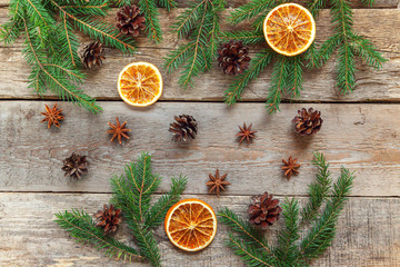 Christmas New Year composition winter objects fir branch pine cones orange slices on old shabby rustic wooden background. Xmas holiday december decoration. Flat lay top view. Time for celebration