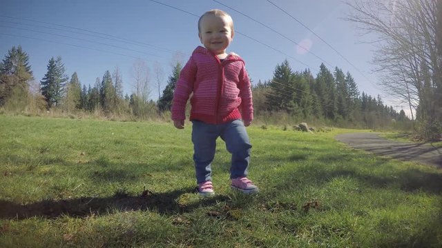 Low POV Baby Girl Walking on Sunny Grass