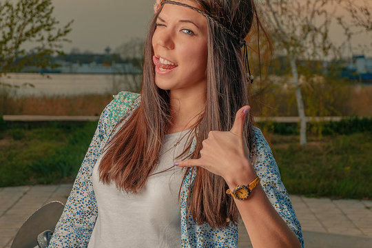 Boho style hipster girl make call-me sign