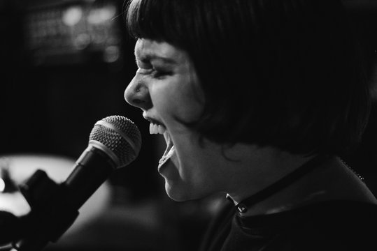 Drummer girl playing and singing during a rehearsal
