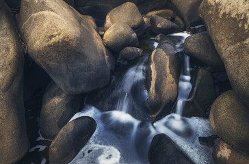 Detail of small creek with rocks and flowing water