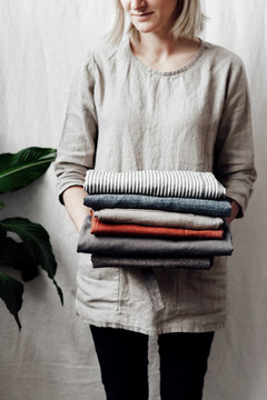 Dressmaker holding a stack of aprons
