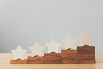 Wooden five star shape on table. The best excellent business services rating customer experience...
