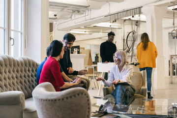 Young Mixed Race People Taking a Break in Bright Office Foyer