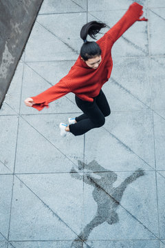 Asian teenage girl with jumping in rainy day