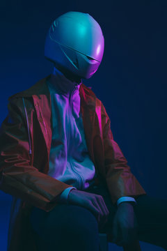 Futuristic person /anonymous with white helmet/mask iluminated with neon light.
