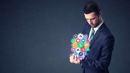 Businessman wearing smartwatch with colored application symbols on it.